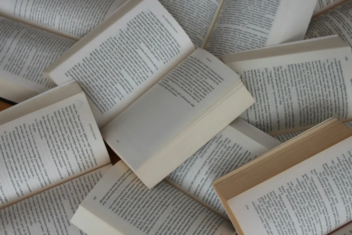 Open books and pages arranged on a table